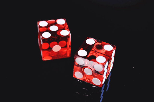 tow red dices on black surface